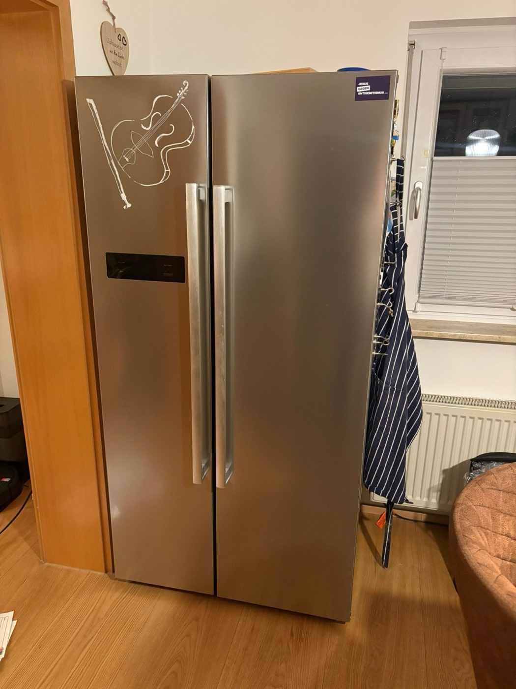 Großer Side-by-Side-Kühlschrank aus Edelstahl vor einer Tür