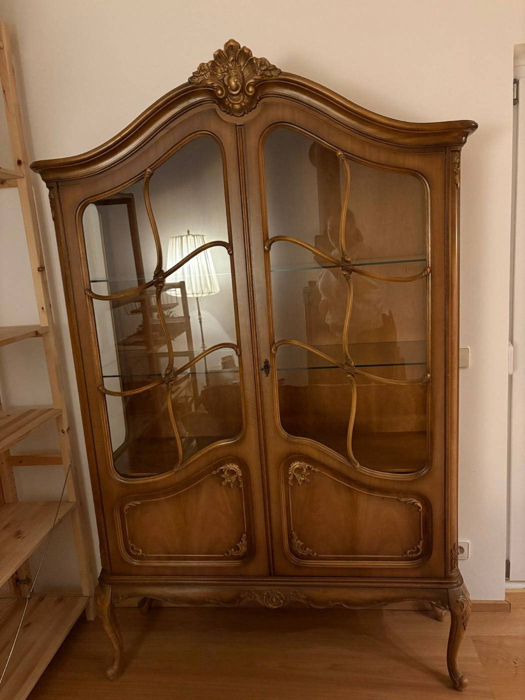 Antike Holzvitrine mit Glastüren und geschnitzter Krone im Haus in Pforzheim