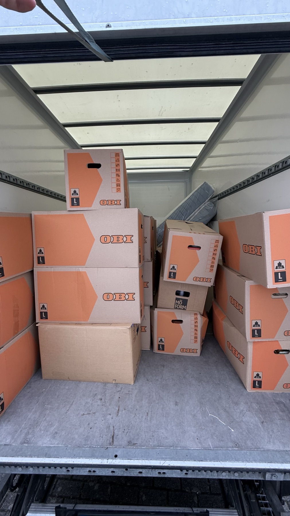Ladefläche eines Transporters, dicht gestapelte Umzugskartons bis unter die Decke