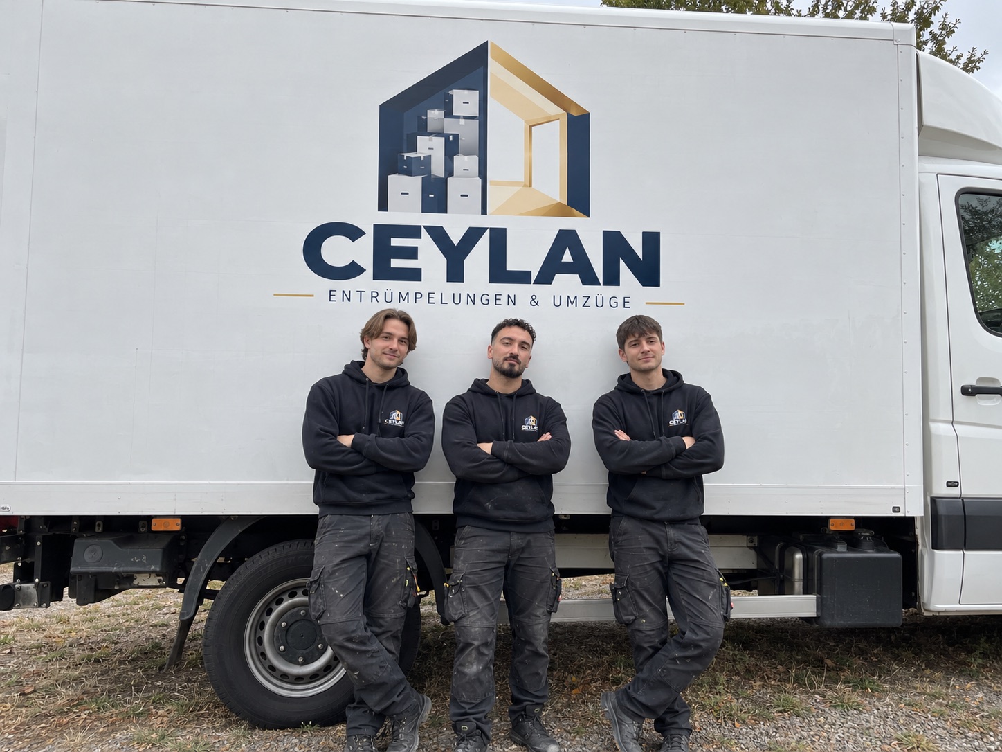 Drei Mitarbeiter von Ceylan lehnen vor dem Firmenwagen mit dem Ceylan-Logo