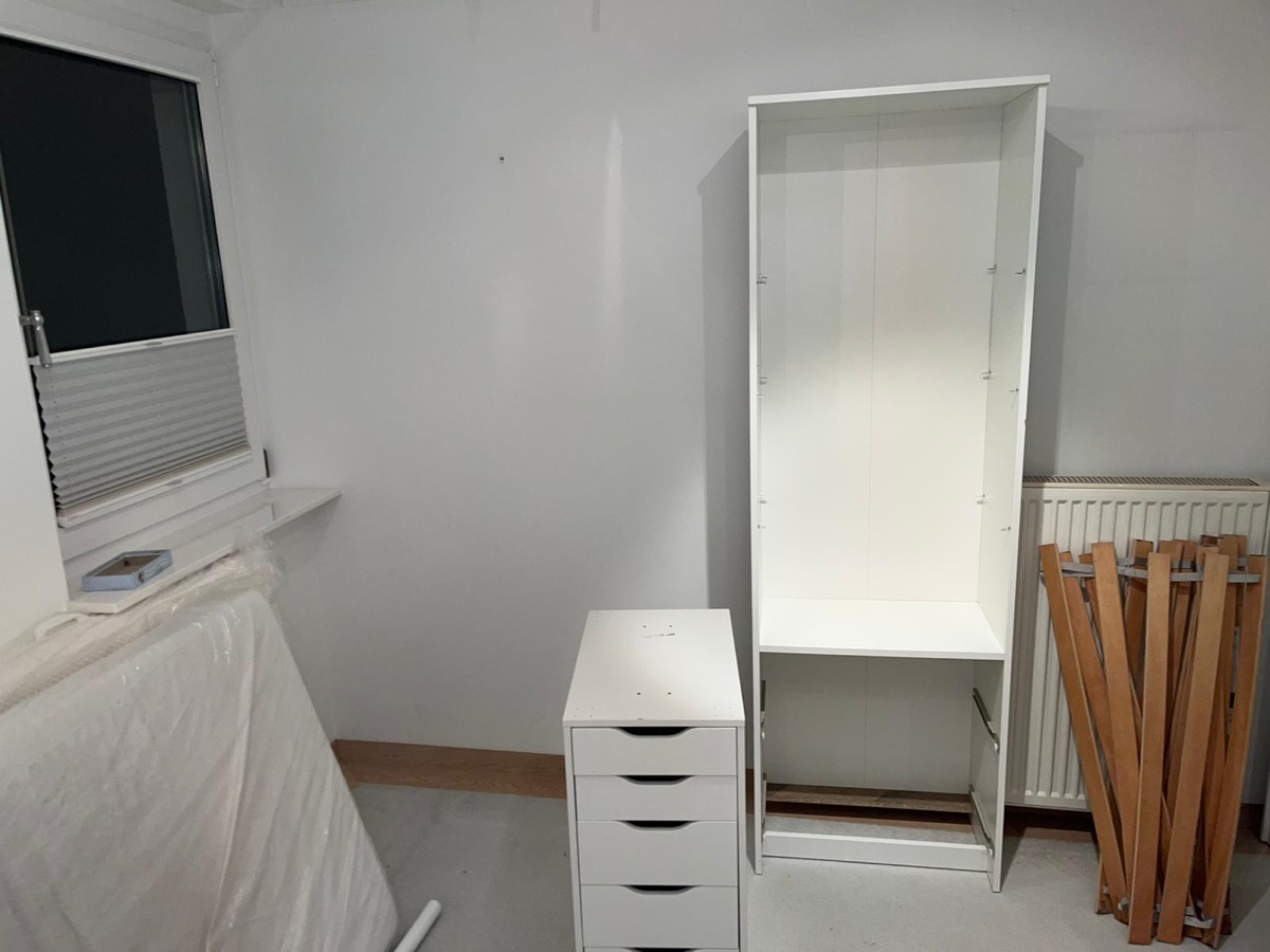 Geräumtes Zimmer mit zerlegtem Schrank, Kommode, folierter Matratze und Lattenrost